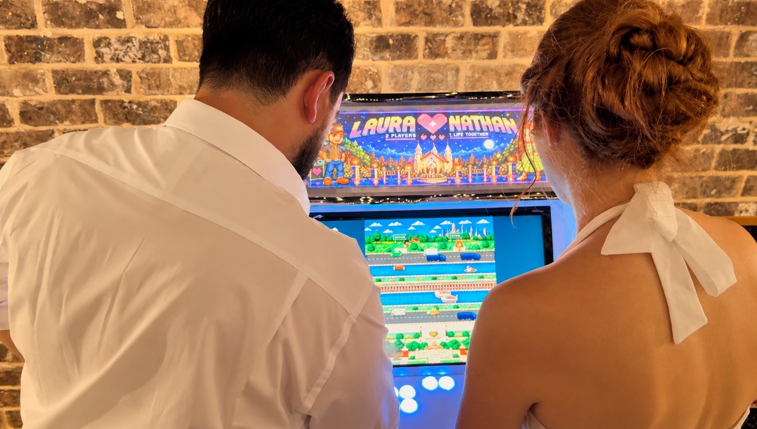 Wedding guests gathered around Laura and Nathan’s arcade game at the reception